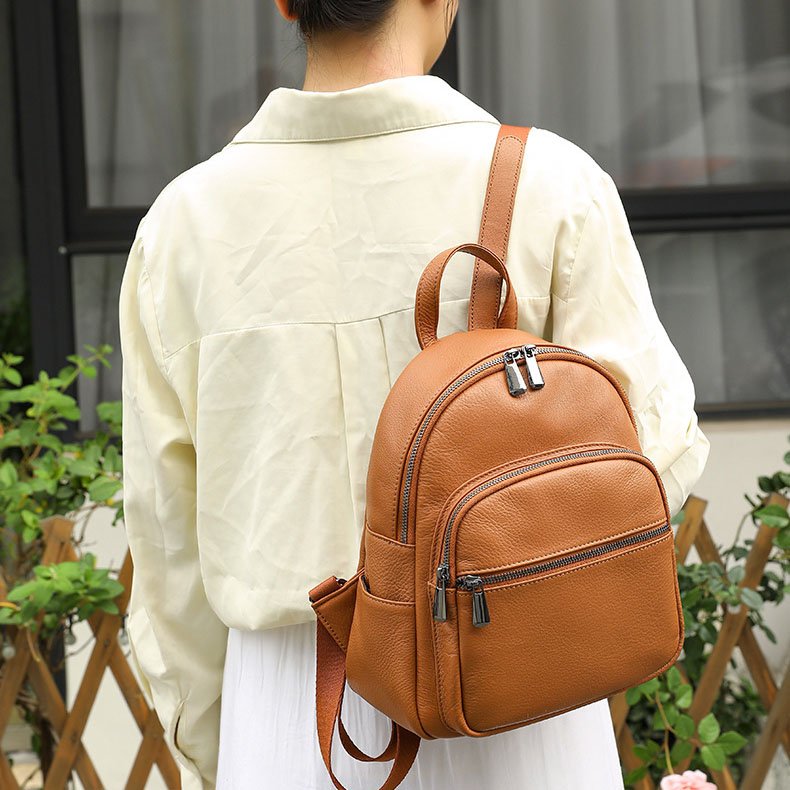 Brown Leather Medium Backpack for Women carrying one strap on shoulder