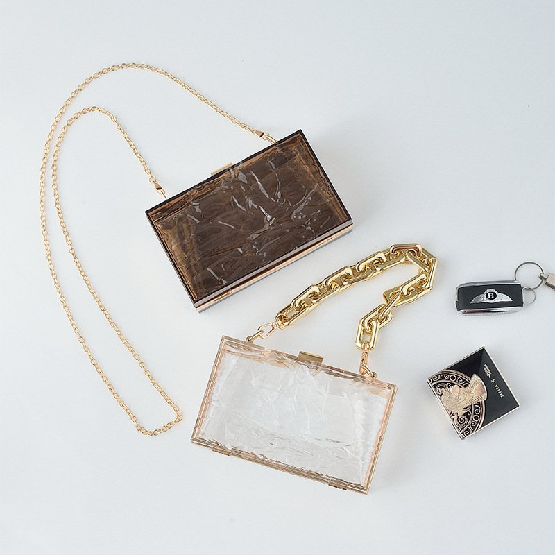 Uneven Transparent Acrylic Book Clutch Bag Ice and brown on floor,with lipstick and powder case