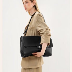 Slouchy Pebbled Leather Maxi Flap shoulder bag Black carrying by a blond hair woman in sand coat