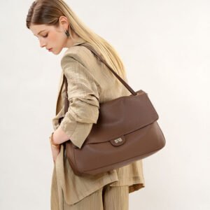 Slouchy Pebbled Leather Maxi Flap shoulder bag Brwon carrying on shoulder,by a blond hair woman in sand coat