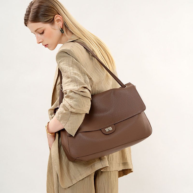 Slouchy Pebbled Leather Maxi Flap shoulder bag Brwon carrying on shoulder,by a blond hair woman in sand coat